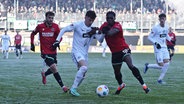 Hannovers Derrick Köhn (2.v.r.) und Elversbergs Hugo Vandermersch kämpfen um den Ball. © IMAGO / Fussball-News Saarland 