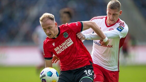 Hannovers Havard Nielsen (l.) und Düsseldorfs Jordy de Wijs kämpfen um den Ball. © picture alliance/dpa | David Inderlied 