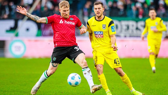 Hannovers Andreas Voglsammer (l.) und Romario Rösch kämpfen um den Ball. © IMAGO / Eibner 