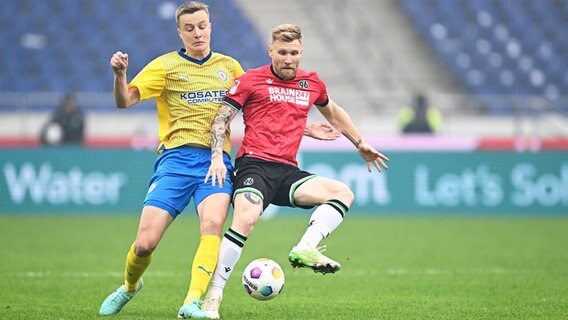 Braunschweigs Robert Ivanov (l.) und Hannovers Andreas Voglsammer kämpfen um den Ball. © IMAGO / osnapix 