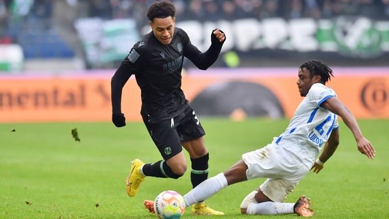 Hannovers Thaddäus-Monju Momuluh (l.) und Rostocks Anderson Lucoqui kämpfen um den Ball. © IMAGO / osnapix 