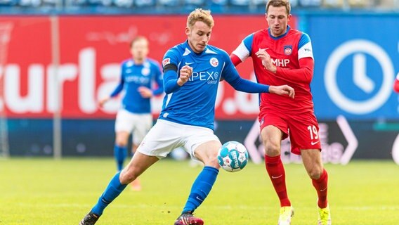 Rostocks Timo Becker (l.) und Heidenheims Jonas Föhrenbach kämpfen um den Ball. © IMAGO / Fotostand 