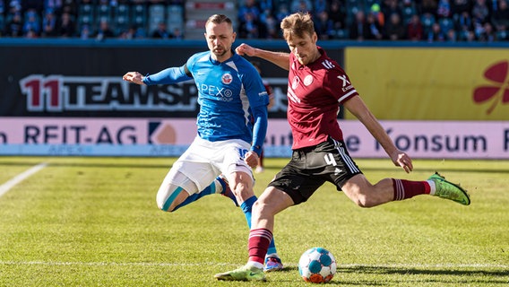 Rostocks John Verhoek (l.) und Nürnbergs Asgar Sörensen kämpfen um den Ball. © IMAGO / Fotostand 