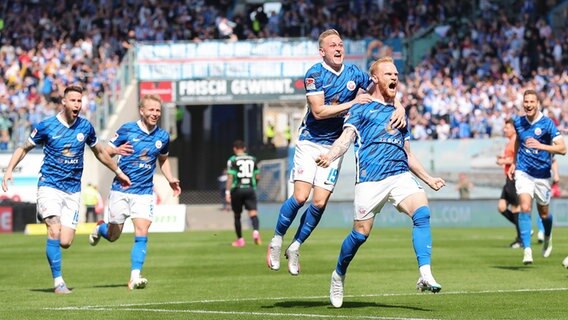 Rostocks Spieler um Torschütze Nils Fröling (r.) bejubeln einen Treffer. © IMAGO / Jan Huebner 