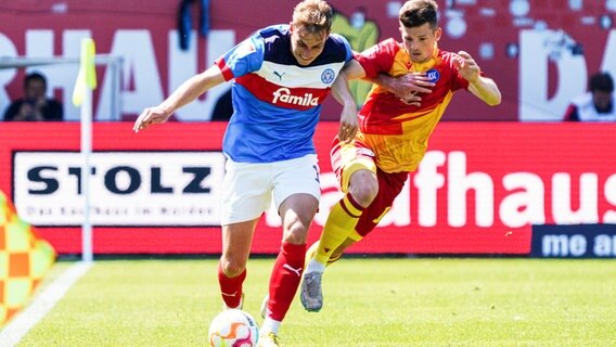 Kiels Timo Becker (l.) und Karlsruhes Marvin Wanitzek kämpfen um den Ball. © IMAGO / Eibner 