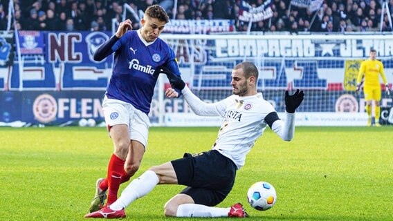 Kiels Benedikt Pichler (l.) und Wiesbadens Aleksandar Vukotic kämpfen um den Ball. © IMAGO / Eibner 