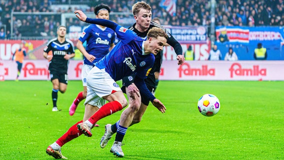 Kiels Finn Porath (l.) und Schalkes Derry-John Murkin kämpfen um den Ball. © IMAGO / Eibner 