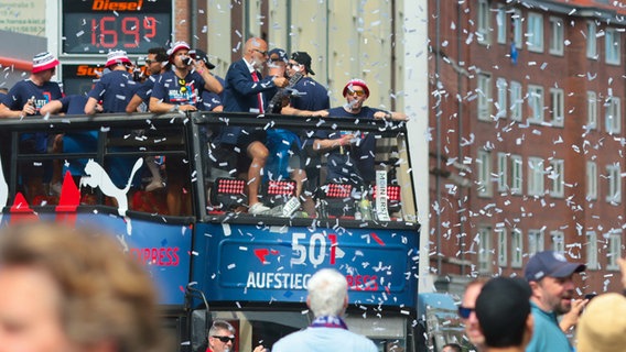 Die Spieler von Holstein Kiel fahren mit einem Bus durch die Innenstadt und werden von ihren Fans gefeiert © picture alliance Foto: Frank Molter