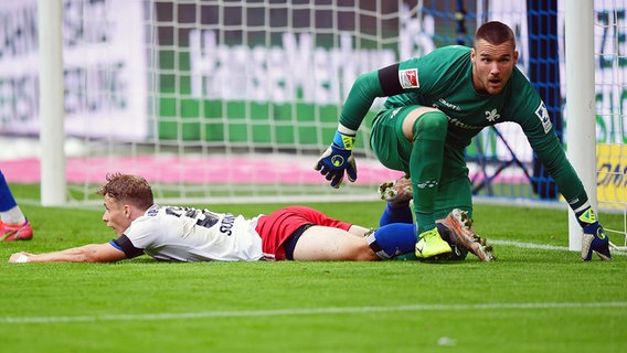 HSV-Spieler Anssi Suhonen am Boden, Darmstadts Torwart Marcel Schuhen schaut dem Ball hinterher. © WITTERS Foto: ValeriaWitters
