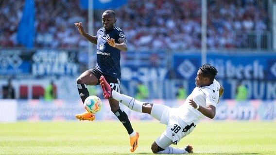 HSV-Akteur Jean-Luc Dompé (l.) und Karlsruhes Franck Evina kämpfen um den Ball. © IMAGO / Eibner 