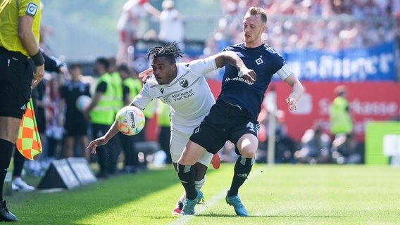HSV-Akteur Sebastian Schonlau (r.) und Karlsruhes Franck Evina kämpfen um den Ball. © IMAGO / Eibner 