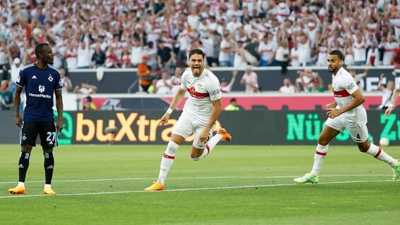 HSV-Spieler Jean-Luc Dompé (l.) ist enttäuscht, während Konstantinos Mavropanos (M.) einen Treffer bejubelt. © IMAGO / HMB-Media 