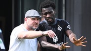 HSV-Trainer Steffen Baumgart (l.) und Bakery Jatta diskutieren miteinander.  © Witters/LennartPreiss 