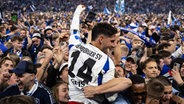 HSV-Spieler Ludovit Reis feiert inmitten von Fans den Aufstieg. © IMAGO / Beautiful Sports 