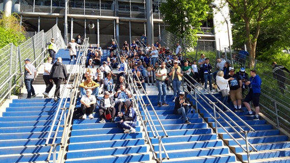 HSV-Fans sitzen auf einer Treppe um den Frauen des Hamburger SV beim Spiel gegen den SC Freiburg II zuzuschauen. © NDR Foto: Florian Neuhauss