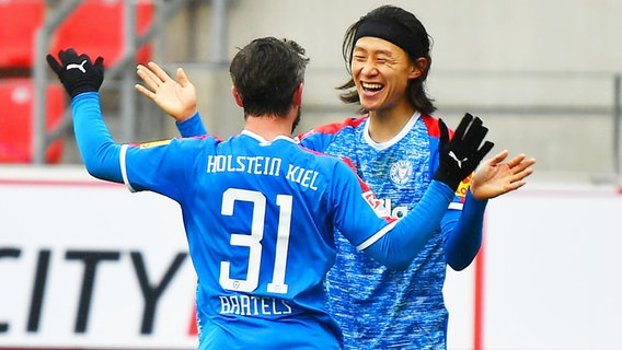 Kiels Torschütze Jae-sung Lee (r.) und Fin Bartels bejubeln einen Treffer gegen Regensburg. © imago images / Zink 