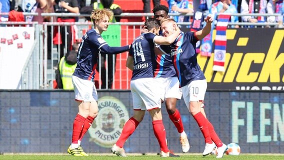 Kiels Spieler Finn Porath, Torschütze Steven Skrzybski, Kwasi Wriedt und Lewis Holtby (v.l.) bejubeln einen Treffer. © IMAGO / Zink 