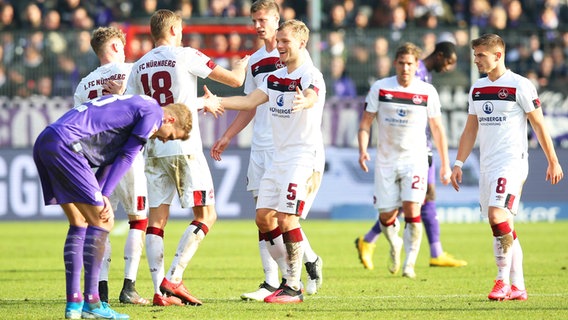 Osnabrücks Joost van Aken (l.) ist bedient, während Nürnbergs Spieler einen Treffer bejubeln. © imago images / foto2press 