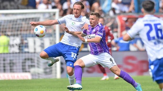 Osnabrücks Erik Engelhardt (r.) und Karlsruhes Robin Bormuth kämpfen um den Ball. © IMAGO / osnapix 