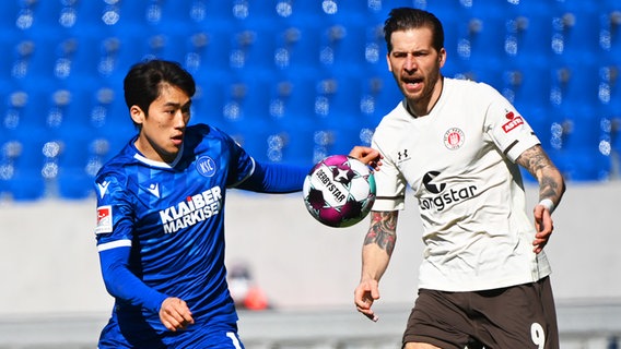 St. Paulis Guido Burgstaller (r.) und Karlsruhes Kyoung-rok Choi kämpfen um den Ball. © dpa-Bildfunk Foto: Uli Deck/dpa