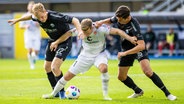 St. Paulis Johannes Eggestein (M.) kämpft gegen Paderborns Mattes Hansen (l.) und Tobias Müller um den Ball. © IMAGO / Moritz Müller 