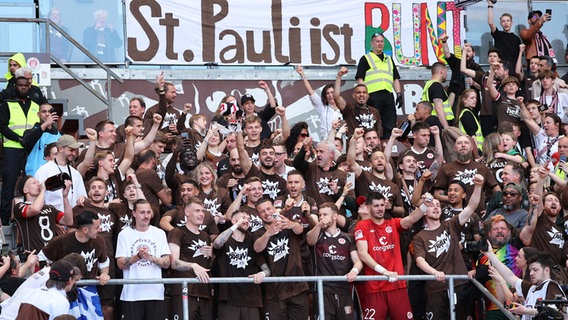 Die Spieler des FC St. Pauli feiern gemeinsam den Bundesliga-Aufstieg. © picture alliance/dpa | Christian Charisius 