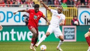 Osnabrücks Oumar Diakhite (r.) und Kaiserslauterns Ragnar Ache kämpfen um den Ball. © IMAGO / Eibner 