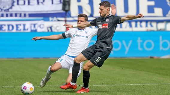 Osnabrücks Charalambos Makridis (r.) und Osnabrücks Tobias Müller kämpfen um den Ball. © IMAGO / Jan Huebner 