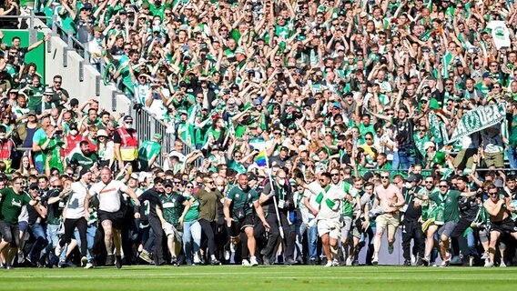 Bremens Fans stürmen den Platz nach dem Schlusspfiff. © IMAGO / Treese 