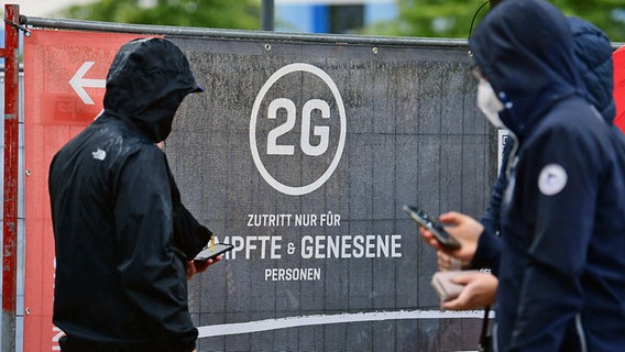 Zuschauer bei den Hamburg Towers vor einem Schild zu den Corona-Einlassbeschränkung © Witters 