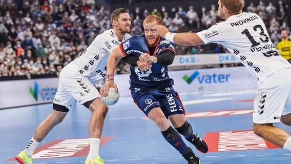 Flensburgs Jim Gottfridsson setzt sich gegen Hendrik Pekerler (l.) und Steffen Weinhold vom THW Kiel durch. © IMAGO / Lobeca 