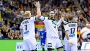 Die Kieler Handball-Nationalspieler Patrick Wiencek, Hendrik Pekeler und Steffen Weinhold (v.l.) klatschen sich ab. © IMAGO / Jörg Schüler 