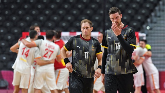 Die Handball-Nationalspieler Steffen Weinhold (l.) und Hendrik Pekeler verlassen bei den Olympischen Spielen in Tokio enttäuscht das Spielfeld. © picture alliance/dpa | Swen Pförtner 