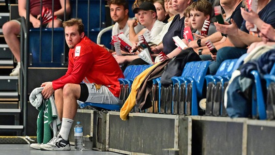 HSV-Handballer Niklas Weller sitzt nach seiner Roten Karte auf der Zuschauertribüne. © Witters 