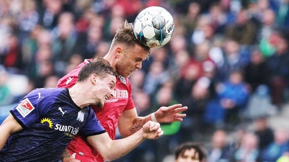Hannovers Marcel Franke (r.) und Osnabrücks Moritz Heyer kämpfen um den Ball. © dpa Foto: Peter Steffen