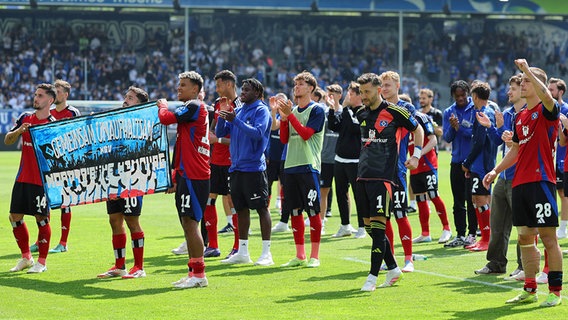 Die Spieler vom Hamburger SV jubeln mit einem Banner. © Witters / Jörg Halisch 