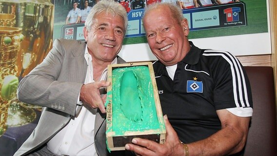 Ex-HSV-Profi Kevin Keegan (l), und der ehemaligen Masseur der Rothosen, Hermann Rieger, posieren mit Keegans Fußabdruck im HSV-Museum. © dpa Foto: Malte Christians