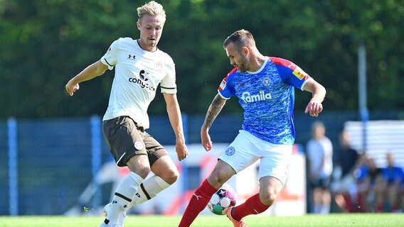 Lukas Daschner (l.) vom FC St. Pauli im Duell mit Holstein Kiels Marco Komenda © Witters Foto: TayDucLam