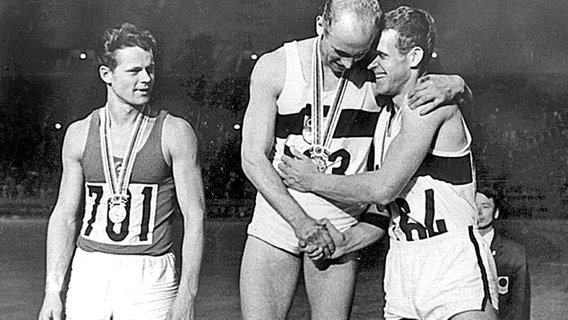 Zehnkampf-Olympiasieger Willi Holdorf (M.) bei der Siegerehrung in Tokio 1964 © picture-alliance/ dpa 