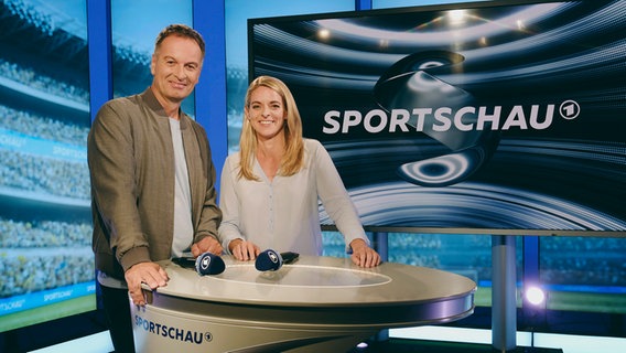 Claus Lufen und Nia Künzer eng nebeneinander stehend in Studio der ARD Sportschau © NDR 