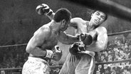 Muhammad Ali kassiert beim WM-Kampf 1971 in New York einen Treffer von Joe Frazier (l.). © picture alliance / ZUMAPRESS.com | Philadelphia Inquirer 