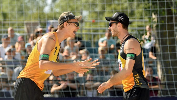 Julius Thole (l.) und Clemens Wickler feuern sich bei der Beachvolleyball-EM in Wien an. © IMAGO / Beautiful Sports 