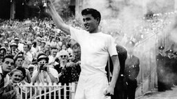 Ron Clarke entzündet 1956 in Melbourne das olympische Feuer. © picture-alliance / dpa