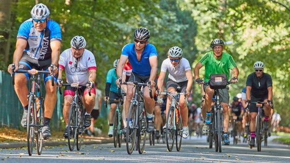 Teilnehmende bei den Cyclassics 2022 in Hamburg nehmen eine Steigung in Blankenese. © Georg Wendt/dpa 