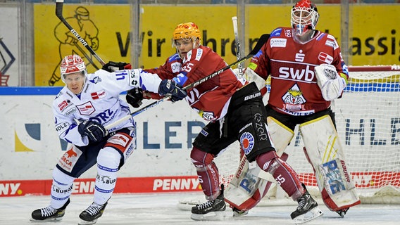 Christian Wejse und Torwart Maximilian Franzreb von den Fischtown Pinguins Bremerhaven versuchen, Ken Andre Olimb (Schwenninger Wild Wings) vom Tor fernzuhalten. © IMAGO / Eibner 