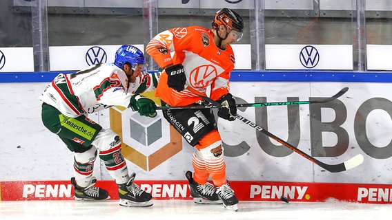 Nolan Zajac (r.) von den Grizzlys Wolfsburg im Duell mit dem Augsburger Adam Johnson © IMAGO / Jan Huebner 