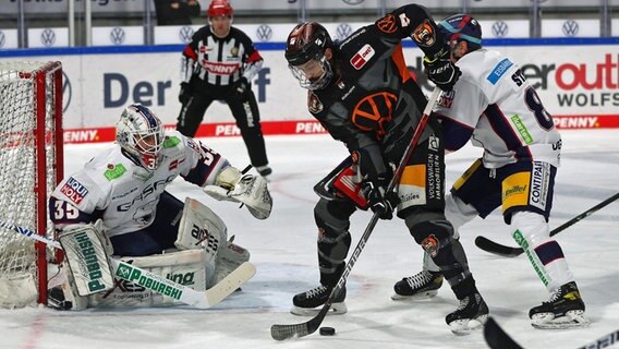 Dominik Bittner (M.) von den Grizzlys Wolfsburg kann sich gegen die Berliner Abwehr nicht durchsetzen. © IMAGO / regios24 