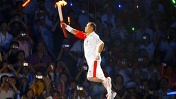 Li Ning entzündet 2008 in Peking das olympische Feuer. © picture-alliance/ dpa