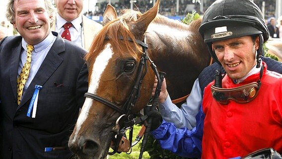 Georg Baron von Ullmann (l) und Jockey Fredrik Johansson freuen sich über den Derby-Sieg von Adlerflug. © dpa Foto: Sebastian Widmann