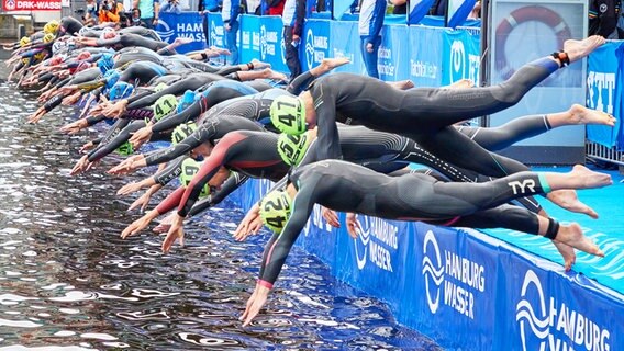 Teilnehmerinnen der Triathlon-Weltmeisterschaft in Hamburg springen beim Start in die Binnenalster © dpa-Bildfunk Foto: Georg Wendt/dpa